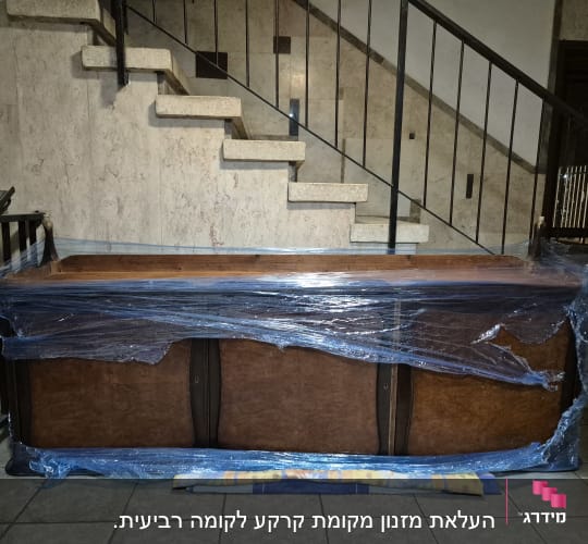 רהיט עטוף בניילון מוכן להובלה במדרגות